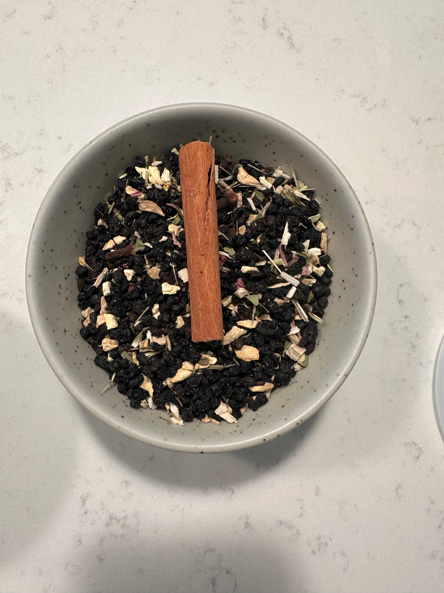 Hand-labeled small batch tea blends in containers — lemon balm, apple cinnamon, and elderberry